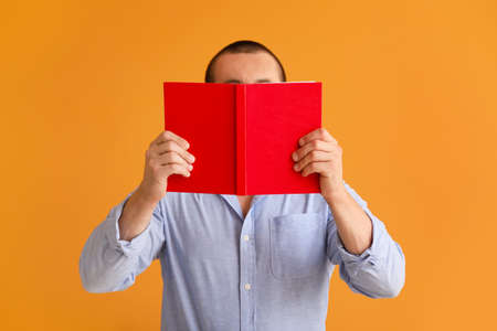 Man with book on color background