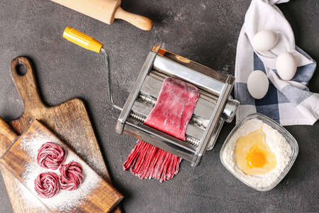 Pasta maker with dough and eggs on dark backgroundの写真素材