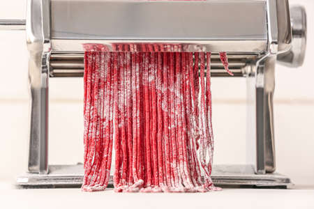 Pasta maker with dough on kitchen table, closeupの写真素材