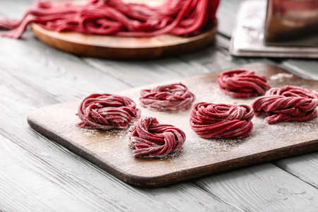 Board with uncooked pasta on tableの写真素材