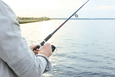 Man fishing on river bank, closeupの写真素材