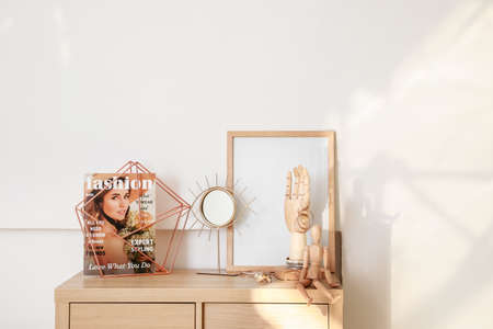 Wooden hand and mannequin with female jewelry on chest of drawers in interior of roomの写真素材