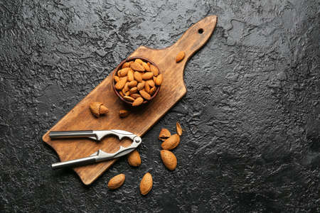 Nutcracker and healthy almonds on dark backgroundの写真素材