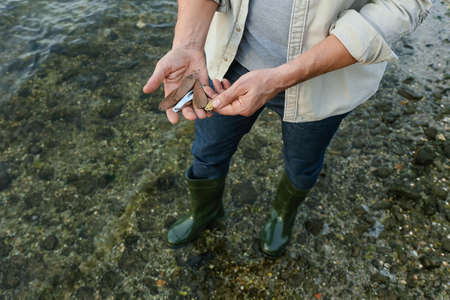 Man with fishing lures on river bankの写真素材