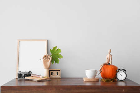 Autumn composition with wooden hand and mannequin on table in roomの写真素材