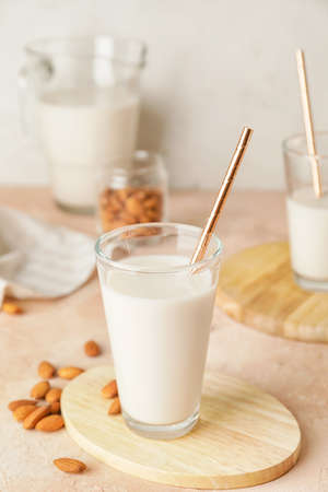 Glass of tasty almond milk on color tableの写真素材