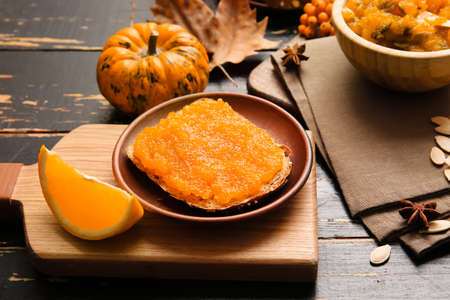 Plate with tasty bread and pumpkin jam on tableの写真素材