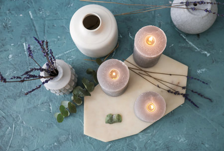 Beautiful aroma candles with lavender flowers on color backgroundの写真素材