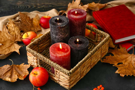 Autumn composition with aroma candles in tray on dark backgroundの写真素材