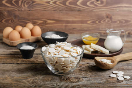 Chocolate drops and ingredients for bakery on wooden backgroundの写真素材