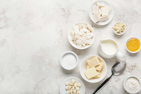 Chocolate drops and ingredients for bakery on light backgroundの写真素材