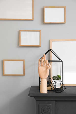 Wooden hand with stylish decor on fireplace in interior of room