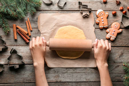 Woman cooking gingerbread cookies at table