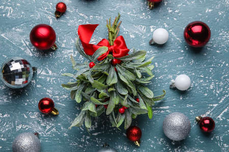 Christmas composition with mistletoe branches and decor on color backgroundの写真素材