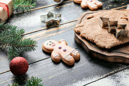 Christmas composition with gingerbread cookie and fresh dough on dark wooden backgroundの写真素材