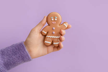Woman holding Christmas cookie on color backgroundの写真素材