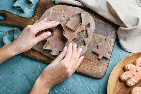Woman cooking gingerbread cookies at table