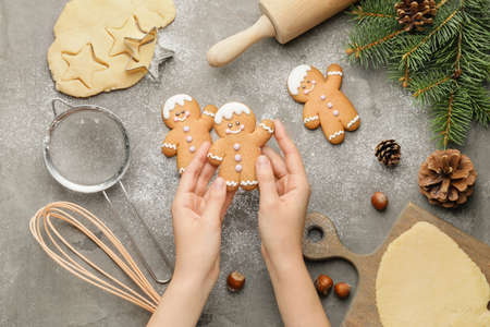 Woman holding Christmas cookie on table
