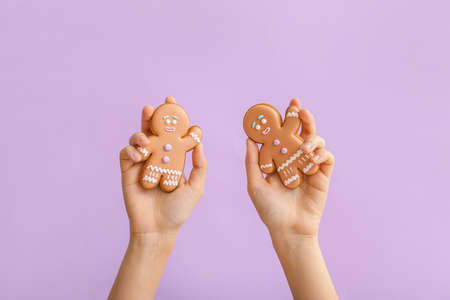 Woman holding Christmas cookies on color backgroundの写真素材