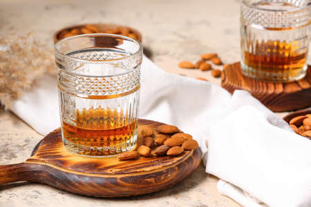 Board with glass of almond liquor and nuts on grunge backgroundの写真素材