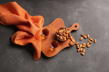 Board with glasses of almond liquor and nuts on dark backgroundの写真素材