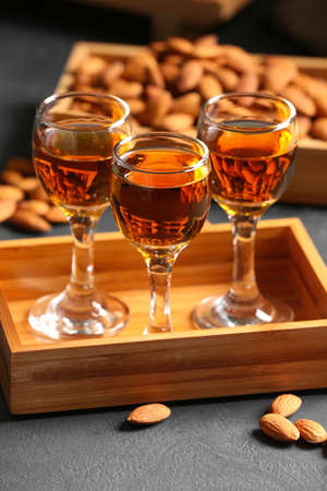Tray with glasses of almond liquor and nuts on dark backgroundの写真素材