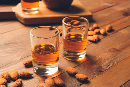 Glasses of almond liquor and nuts on wooden backgroundの写真素材