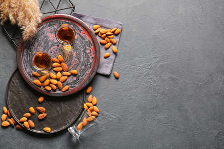 Tray with glasses of almond liquor and nuts on dark backgroundの写真素材
