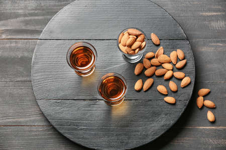 Tray with glasses of almond liquor and nuts on dark wooden backgroundの写真素材