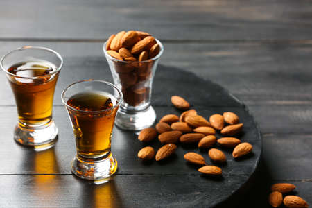 Tray with glasses of almond liquor and nuts on dark wooden backgroundの写真素材