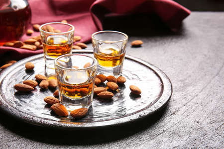 Tray with glasses of almond liquor and nuts on dark backgroundの写真素材