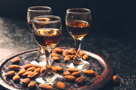 Tray with glasses of almond liquor and nuts on dark backgroundの写真素材