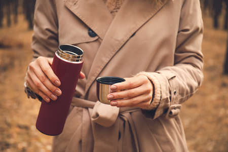 Young woman with drinking hot tea in forest, closeupの写真素材