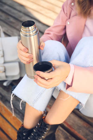 Young woman with drinking hot tea outdoorsの写真素材