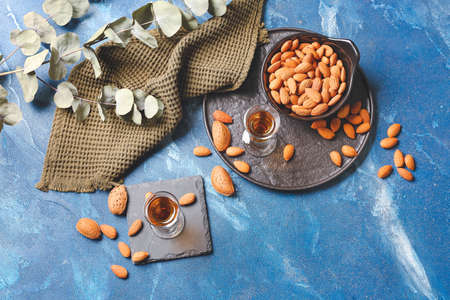 Composition with glasses of almond liquor and nuts on color backgroundの写真素材