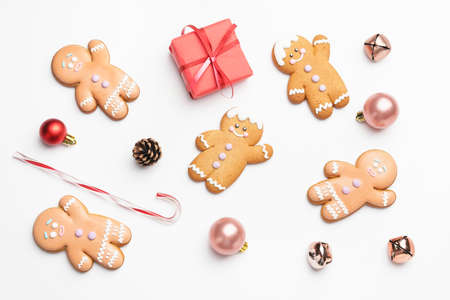 Tasty gingerbread cookies and Christmas decor on white background
