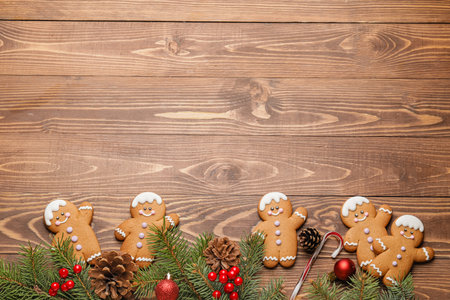 Tasty gingerbread cookies and Christmas decor on wooden background