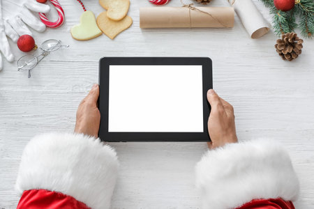 Santa Claus with tablet computer at tableの写真素材