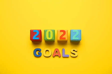 Composition with text 2022 GOALS on color background