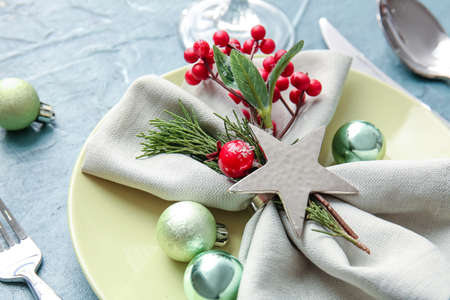 Beautiful Christmas table setting with mistletoe on color backgroundの写真素材