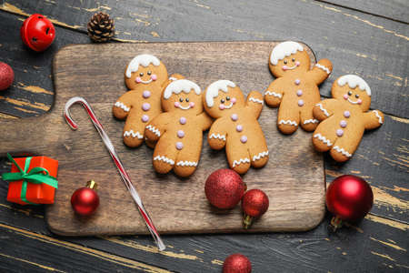 Tasty gingerbread cookies and Christmas decor on wooden background
