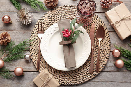Beautiful Christmas table setting with mistletoe on wooden background