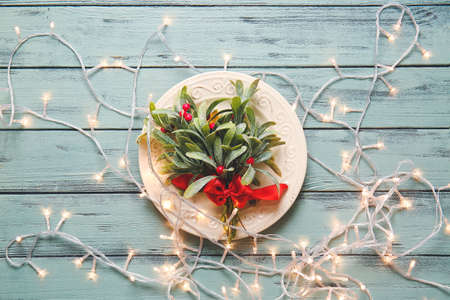 Beautiful Christmas table setting with mistletoe on color wooden backgroundの写真素材