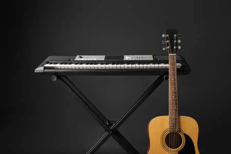 Acoustic guitar and synthesizer on dark background