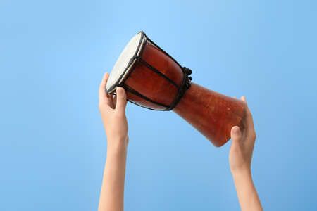 Woman holding djembe on color backgroundの写真素材
