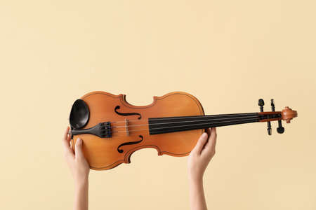 Woman holding violin on color backgroundの写真素材