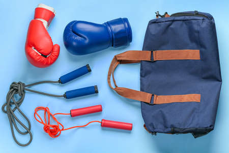 Sports bag, boxing gloves and skipping ropes on color backgroundの写真素材