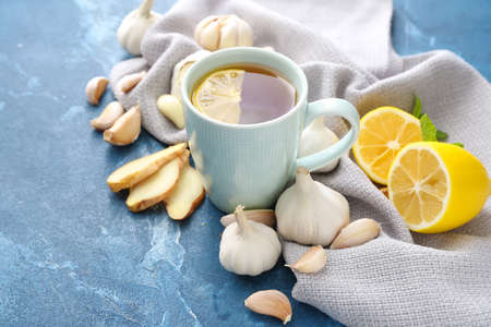 Cup of healthy garlic tea on color backgroundの写真素材