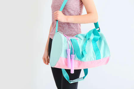 Young woman with sports bag on white backgroundの写真素材