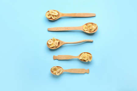 Spoons with crispy banana chips on color backgroundの写真素材